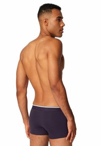 Boxer attillati da uomo di un viola scuro con un elastico bianco in vita, che mostrano una trama di tessuto liscia e un design aderente.