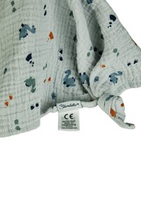 Cotton muslin blanket, light gray with colorful dinosaur patterns. Features a knotted corner and care label. Soft, textured fabric.
