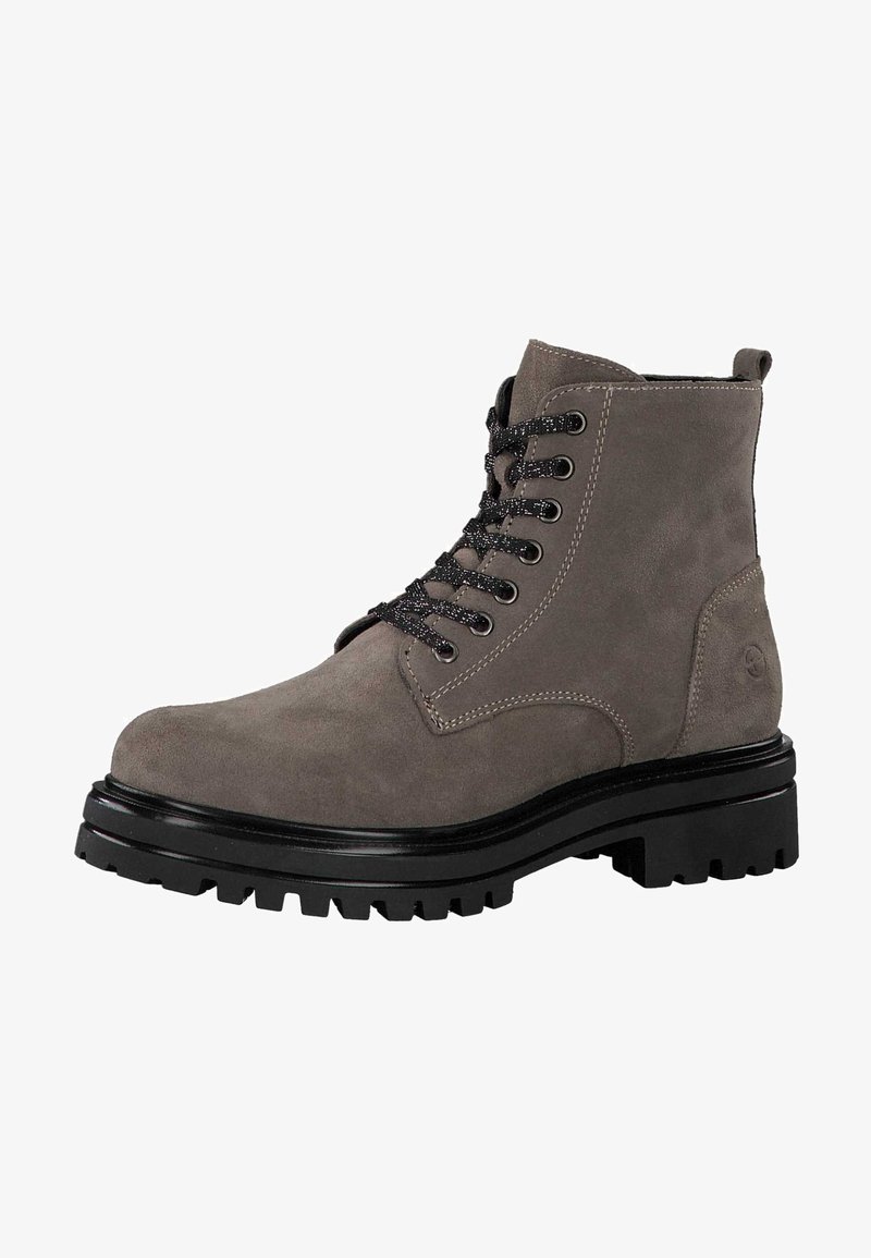 Bottine en daim gris avec lacets noirs, bout rond, semelle noire robuste et détails de couture visibles sur les côtés et le talon.