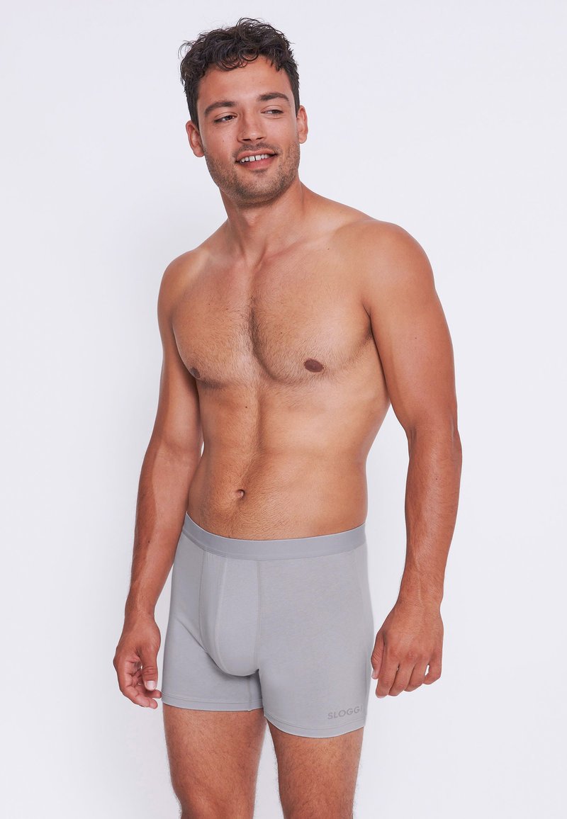 Boxer in grigio realizzati in un tessuto morbido e elastico. Presentano un comodo elastico in vita e una vestibilità aderente, con un logo del marchio discreto sul lato.