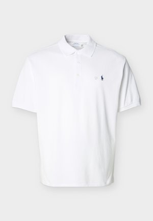 Balta īsroku polo krekls ar apkakli, trim pogām un nelielu tumši zilu izšūtu logotipu kreisā krūšu rajonā.