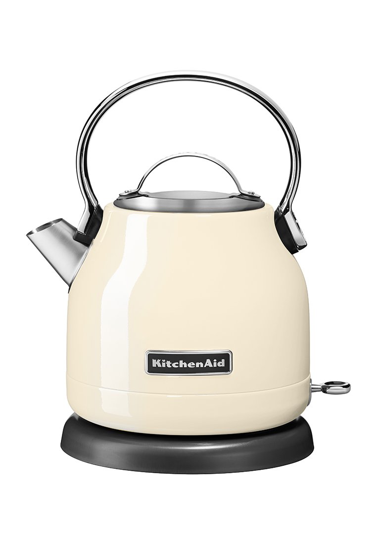 Cremefarbener KitchenAid Wasserkocher mit einem Edelstahlgriff und einer Auslauföffnung, der auf einer schwarzen runden Basis steht.