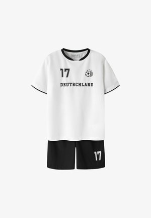 Fehér focimez fekete gallérral és szegéllyel, elöl "17" és "DEUTSCHLAND", hozzáillő fekete rövidnadrág, bal lábon "17"-es szám.