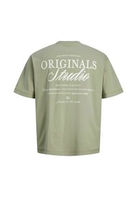 Λαδί πράσινο T-shirt με λευκό κείμενο "ORIGINALS Studio" και μικρότερες φράσεις για το σχεδιασμό και τη δημιουργικότητα στην πλάτη.