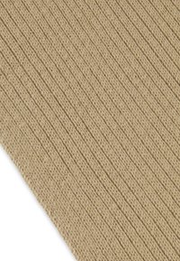 Tissu beige texturé avec un design strié et des détails de fil visibles. Matériau doux avec un motif uniforme et des variations de couleur naturelles.