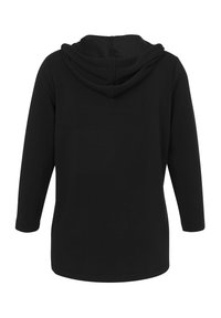 Schwarzer Kapuzenpullover mit langen Ärmeln. Weicher Stoff. Gerader Schnitt, ohne Muster oder Akzente, mit einem schlichten Design.