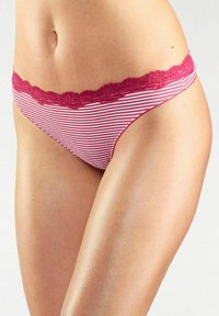 Gestreepte bikini met een rode kantafwerking. De stof is zacht met een rekbare textuur en heeft horizontale witte en roze strepen.