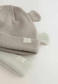 Hellgraue, gerippte Strickmützen mit runden Ohren. Der obere Teil der Mütze ist dunkler, beide verfügen über ein kleines Etikett mit "little one". Weiche Textur.