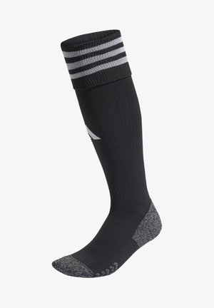 Calza sportiva nera al ginocchio con strisce bianche nella parte superiore, texture a coste, punta rinforzata e tallone e suola grigi a contrasto.