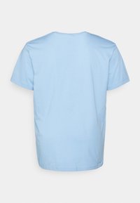 Jasnoniebieska bawełniana koszulka z okrągłym dekoltem i krótkimi rękawami. Miękka tekstura, prosty krój bez widocznych logo ani wzorów z tyłu.