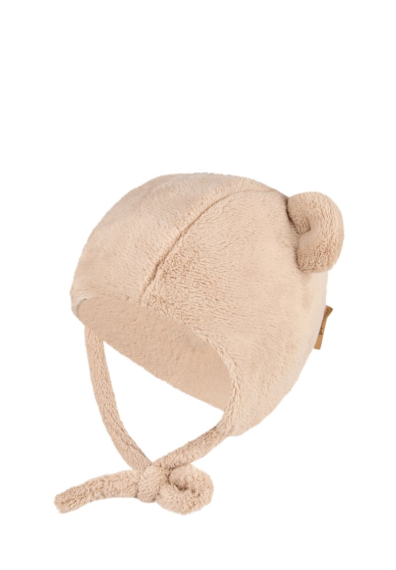 Beige soft plush baby hat with ear flaps, tied chin straps, and a small round fabric ear on top.