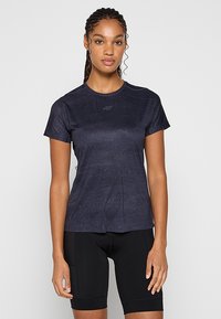 Granatowa koszulka sportowa z krótkim rękawem, wykonana z teksturowanej tkaniny, z dyskretnym logo na piersi, połączona z czarnymi szortami kolarskimi.