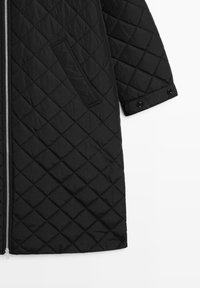 Schwarzer gesteppter Mantel aus synthetischem Material mit einem Reißverschluss vorne, seitlichen Taschen und Druckknopfärmeln. Mit strukturiertem Rautenmuster.