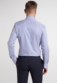 Blauw-wit gestreepte overhemd met lange mouwen, knoopmanchetten en een medium spreidkraag, gecombineerd met donkere broeken.