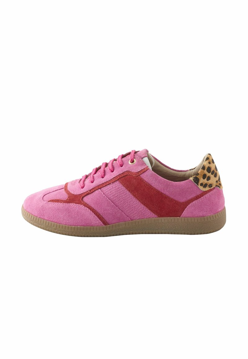 Rosa Wildleder-Sneaker mit roten Akzenten, Leopardenmuster an der Fersenschlaufe, Gummisohle und rosa Schnürsenkeln, von der Seite auf einem weißen Hintergrund dargestellt.