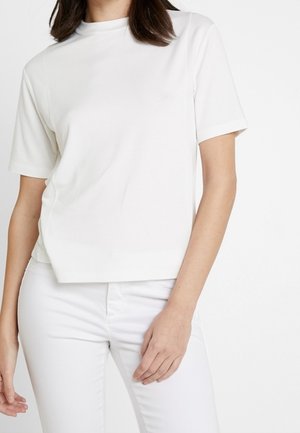 Witte T-shirt met korte mouwen, gemaakt van gladde stof, met een ronde hals en een iets losser vallende pasvorm. Gecombineerd met witte broek voor een monochrome uitstraling.