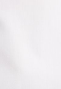 Sternförmige Schokoladenkekse auf Pergamentpapier neben einer Schüssel mit Keksen und einem aufgeschlagenen Kochbuch mit einem Keksrezept.