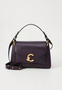 Bolso de cuero morado con una silueta curva, herrajes dorados y un broche distintivo en forma de C. Incluye una correa de hombro desmontable.