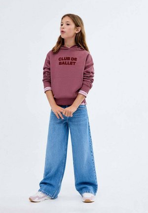 Sweat-shirt à capuche bordeaux avec "CLUB DE BALLET" imprimé en marron, associé à un jean large bleu clair et des baskets blanches avec des accents roses.