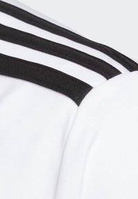 Camiseta atlética blanca con franjas textiles negras a lo largo del hombro y el cuello, con una textura de tela suave y un diseño ajustado.