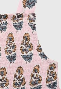 Rosa klänning i tyg med smock-detaljer, prydd med ett blommönster i blått och brunt. Inkluderar justerbara remmar för passform.