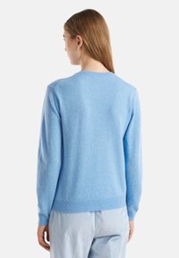 Helles blaues Strickpullover mit langen Ärmeln, rundem Halsausschnitt und geripptem Saum. Der Stoff hat eine weiche Textur und einen leicht schimmernden Finish.