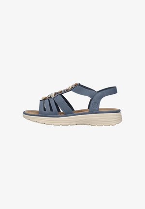 Sandale bleue avec des embellissements en gemmes, design à bout ouvert, sangles élastiques et semelle rembourrée beige. Présente une légère arche pour le soutien.