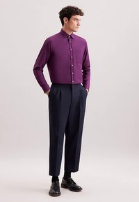 Lila Hemd mit Knöpfen und einer Tasche, kombiniert mit hoch taillierter marineblauer Hose und schwarzen Schuhen, mit einer strukturierten Gestaltung und glattem Stoff.