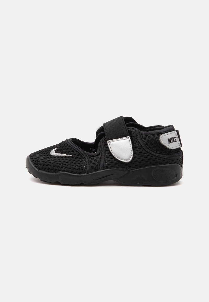 Μαύρο αθλητικό παπούτσι Nike από δίχτυ με μία φαρδιά λωρίδα βέλκρο και λευκές ετικέτες λογότυπου στο πλάι και στην φτέρνα.