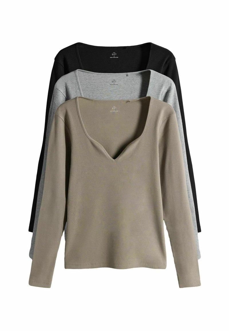 Tre magliette a maniche lunghe nei colori beige, grigio e nero. Ognuna presenta un colletto a V e una texture a coste, con la maglietta beige in primo piano.