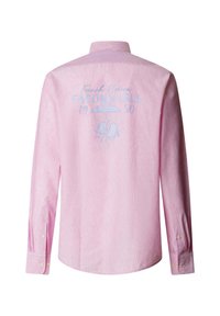 Lichtroze blouse met lange mouwen en knoopmanchetten, voorzien van blauwe tekst "French Riviera Façonnable 1950" en een afbeelding van een strandparasol met twee stoelen op de achterkant.