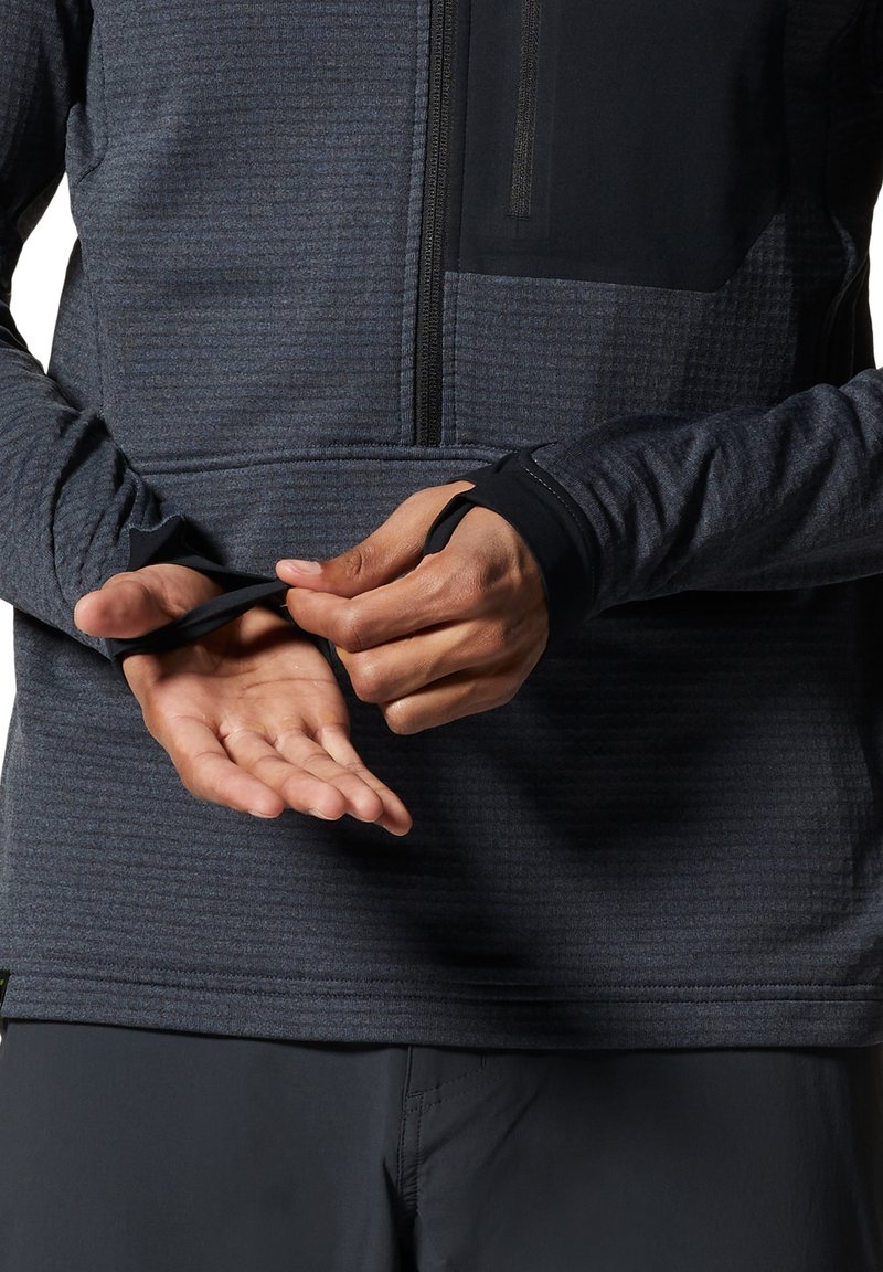 Męska ciemnoniebieska koszula z długim rękawem o teksturowanej powierzchni, z czarnymi akcentami i kieszenią na zamek, z otworami na kciuki przy mankietach dla pewnego dopasowania.