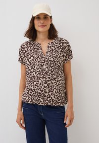 Top à imprimé léopard en beige et marron, à manches courtes, décolleté en V, en tissu léger, assorti à un pantalon en denim noir à coupe décontractée.