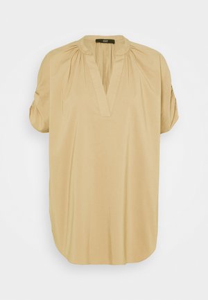 Blusa beige de manga corta con escote en V, hombros fruncidos y un pequeño cuello mao, mostrada sobre un fondo liso.