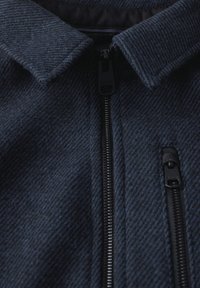 Mörkblå, texturerad ull zip-jacka med krage och två framfickor med dragkedja, med svarta dragkedjor och detaljer.