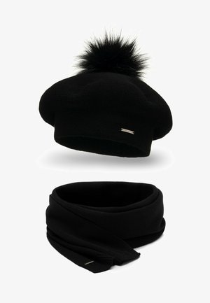 Béret en tricot noir avec un pompon duveteux et une écharpe infinity assortie. Les deux articles présentent un subtil accent métallique. Texture douce, design simple.