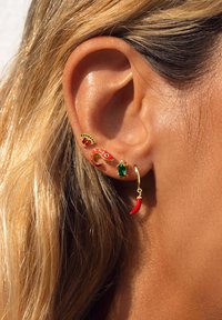 Boucles d'oreilles dorées ornées d'un mélange de charme colorés : poisson rouge, pierre verte, piment rouge et une forme de demi-lune avec des accents verts.