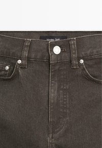 Mörkgrå denimjeans med en klassisk femficksdesign, metallbeslag och kontrasterande sömnad längs sömmarna.
