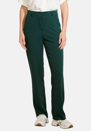 Pantaloni verdi, su misura, realizzati in un tessuto liscio, con zip frontale, chiusura con bottone e tasche laterali. Design a gamba dritta.
