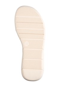 Suola di scarpa in gomma beige chiaro caratterizzata da modelli di grip testurizzati e scanalature orizzontali per una migliore aderenza, con punta rotonda e design piatto.