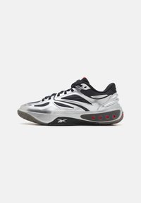 Des chaussures de sport argentées avec un design épur�é, une tige en textile noir et des accents rouges. Semelle extérieure en caoutchouc texturé avec des éléments de coussinage visibles.