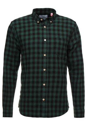 Camisa de franela a cuadros verdes y negros con cuello abotonado, botones de madera y un pequeño bolsillo en el pecho. Textura de tela suave.