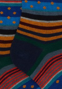 Calze multicolore con strisce blu, verdi, arancioni e navy, decorate con pois e texture contrastanti, realizzate in materiale lavorato a maglia.