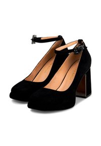 Scarpe col tacco alto in suede nero con punta quadrata, cinturino alla caviglia con hardware metallico e tacco a blocco con un accento lucido.