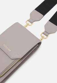 Szara skórzana torebka na ramię z teksturowanym paskiem. Posiada złoty zamek błyskawiczny, detal z logo oraz kieszeń z zapięciem na zatrzask. Dodatki obejmują złote akcesoria.
