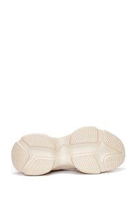 Light-colored sneaker sole with a textured pattern, featuring distinct traction grooves and rounded edges. The material appears rubbery and flexible.