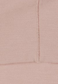 Helles rosa dehnbares Material mit vertikaler Rippstruktur, das an einer Kante eine schmale, genähte Naht aufweist. Glattes, weiches Material.