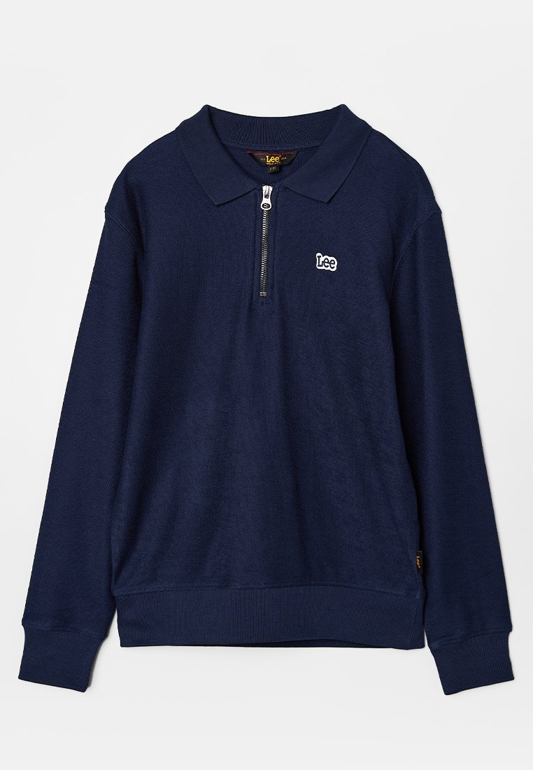 Polo à manches longues bleu marine avec col zippé, arborant un petit logo blanc sur la poitrine, fabriqué en tissu texturé et avec des poignets côtelés.