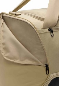 Beige zachte tas met een ritsopening, met een gestructureerd oppervlak en zwarte accenten. Inclusief een zijvak en duurzame hengsels.