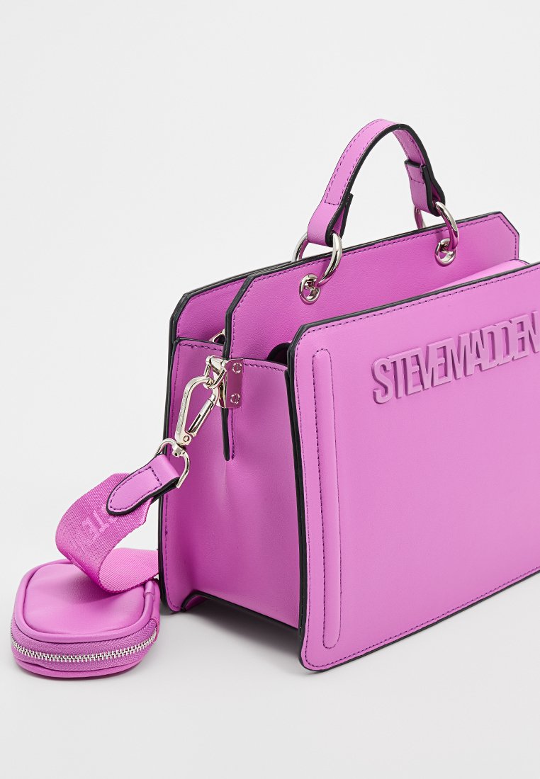 Sac à main Steve Madden d'un violet éclatant avec des poignées supérieures, une bandoulière détachable et une petite pochette zippée sur fond blanc.